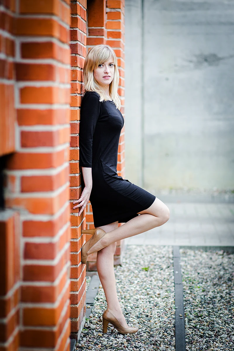Elegancka poza, modelka w loftach, czarna sukienka, Sesja Modowa Księży Młyn.
