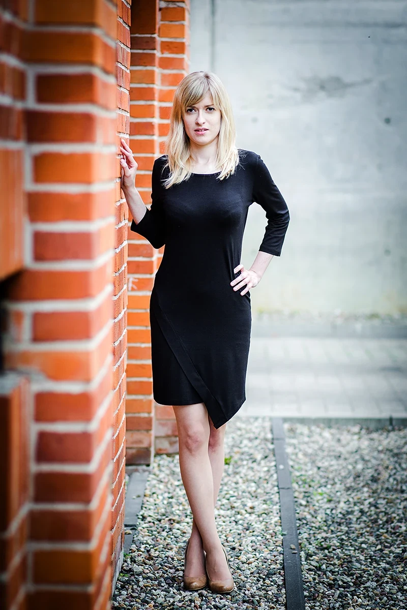 Elegancka poza, modelka w loftach, czarna sukienka, Sesja Modowa Księży Młyn.