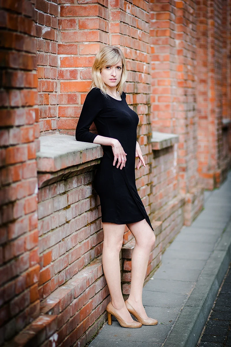 Elegancka poza, modelka w loftach, czarna sukienka, Sesja Modowa Księży Młyn.