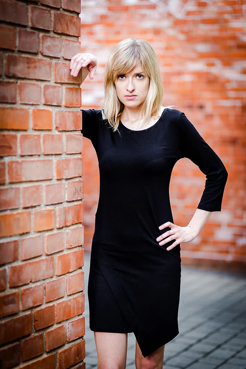 Elegancka poza, modelka w loftach, czarna sukienka, Sesja Modowa Księży Młyn.