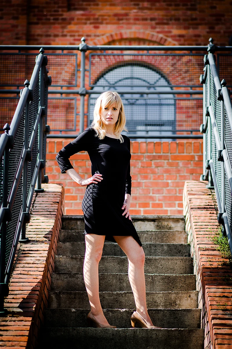 Elegancka poza, modelka w loftach, czarna sukienka, Sesja Modowa Księży Młyn.