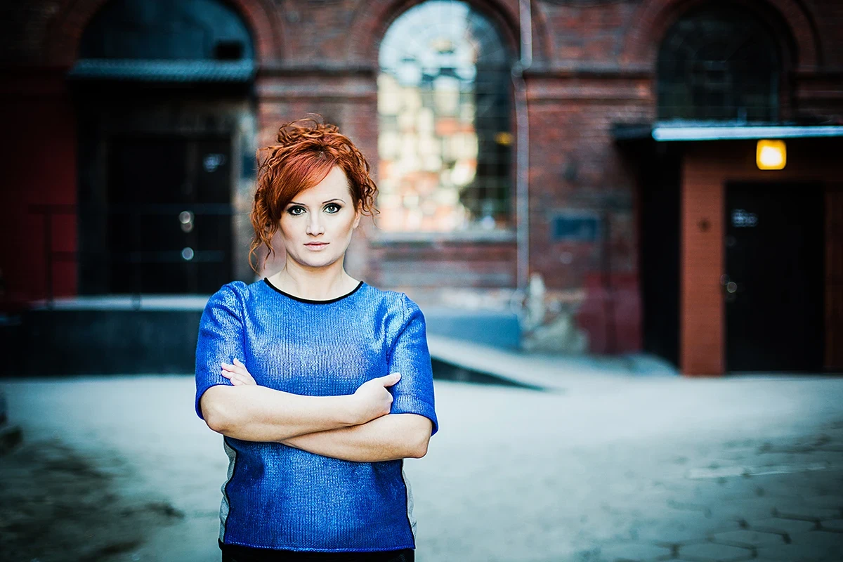 Zdjęcia do kampanii modowej Łódź – Model pozujący na dziedzińcu, ujęcie ukazujące architekturę.