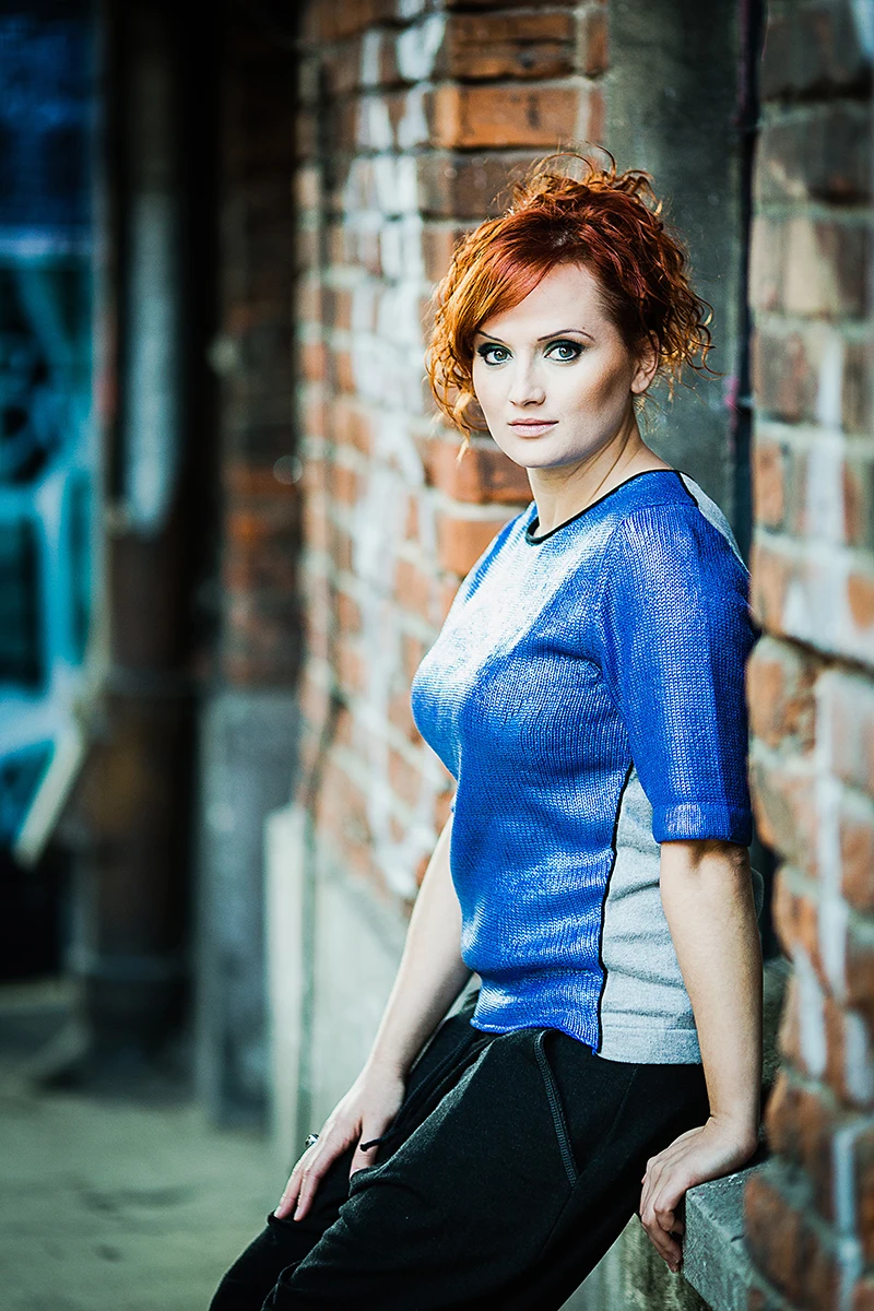 Sesja wizerunkowa OFF Piotrkowska – Model pozujący na dziedzińcu, ujęcie ukazujące architekturę.