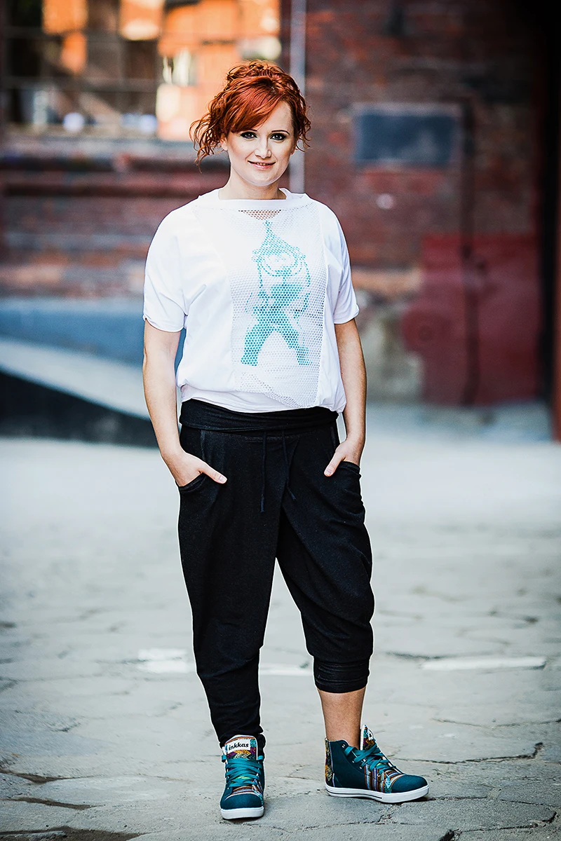 Sesja wizerunkowa OFF Piotrkowska – Model pozujący na dziedzińcu, ujęcie ukazujące architekturę.