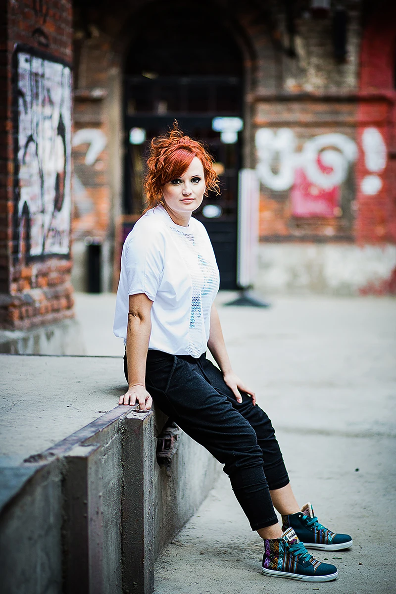 Sesja wizerunkowa OFF Piotrkowska – Model pozujący na dziedzińcu, ujęcie ukazujące architekturę.