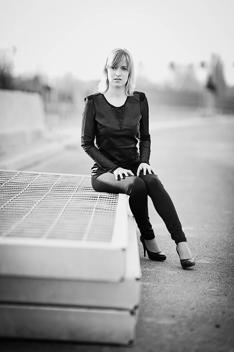 Czarne szpilki i legginsy kontrastujące z asfaltem autostrady