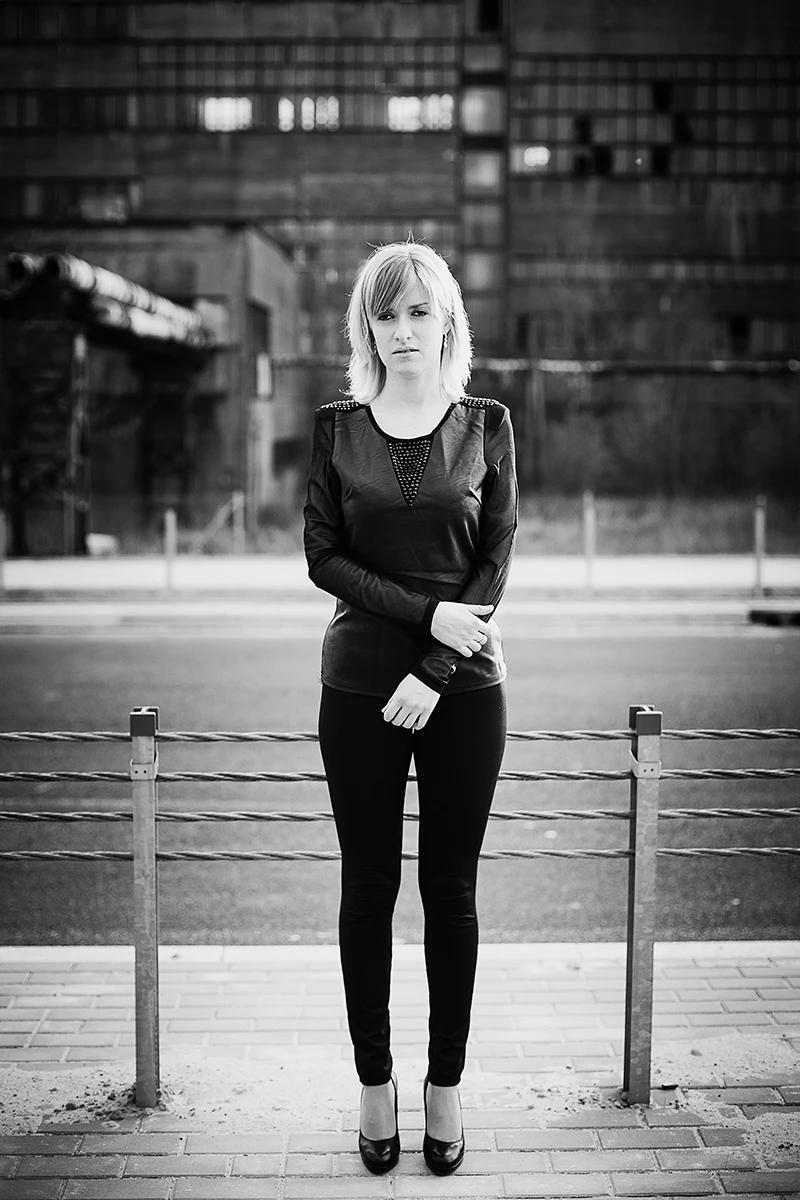 Czarne szpilki i legginsy kontrastujące z asfaltem autostrady